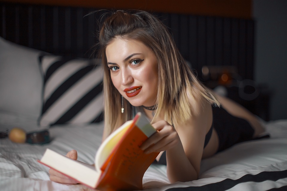 ベッドで本読む女性